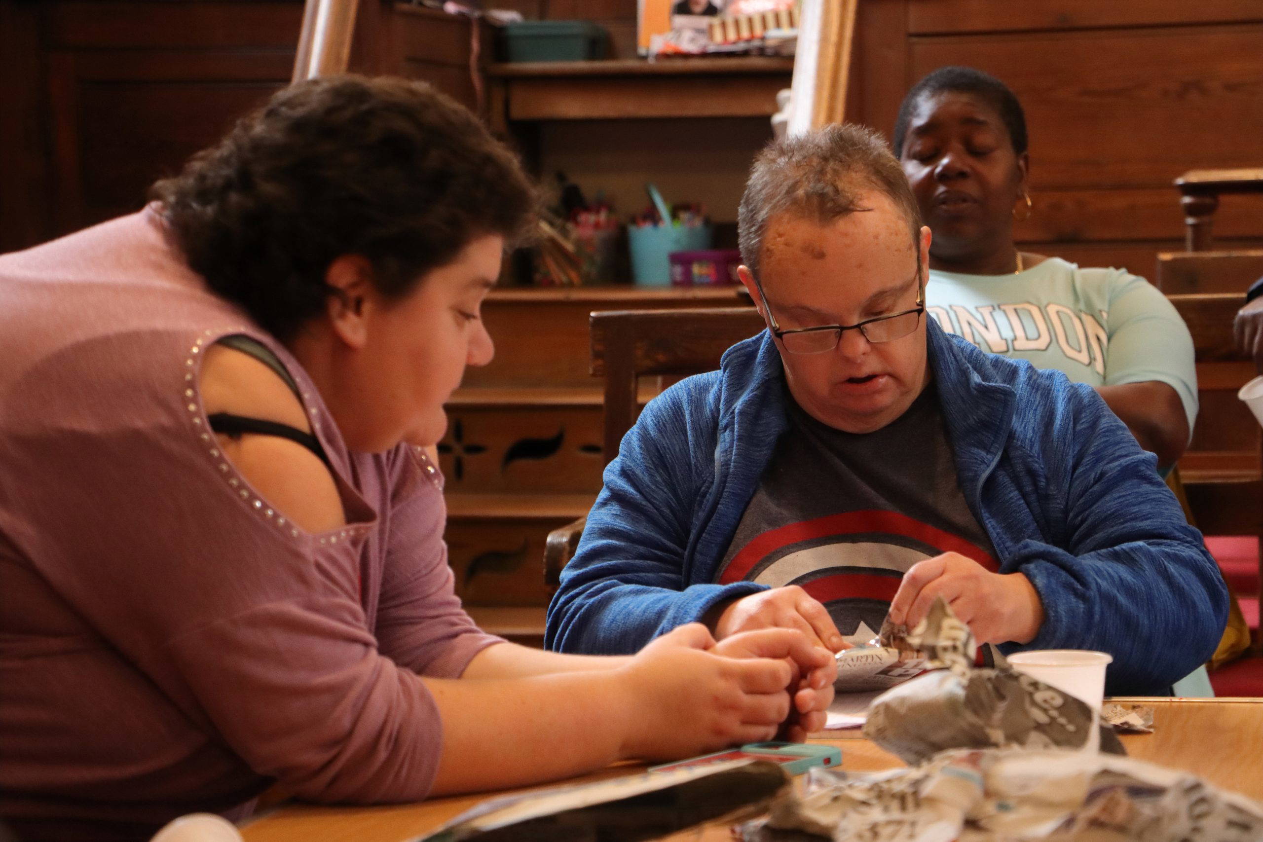 Staff and a member doing arts and crafts at the Hub